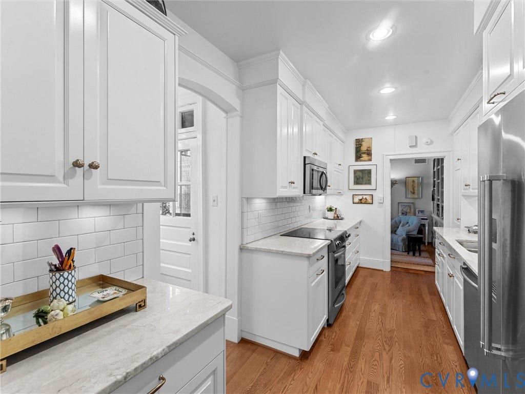 5621 Cary Street Road, #U506, Richmond, VA 23226 Kitchen featuring white cabinetry, stone countertops, subway tile backsplash, stainless steel appliances, and wood-finish flooring