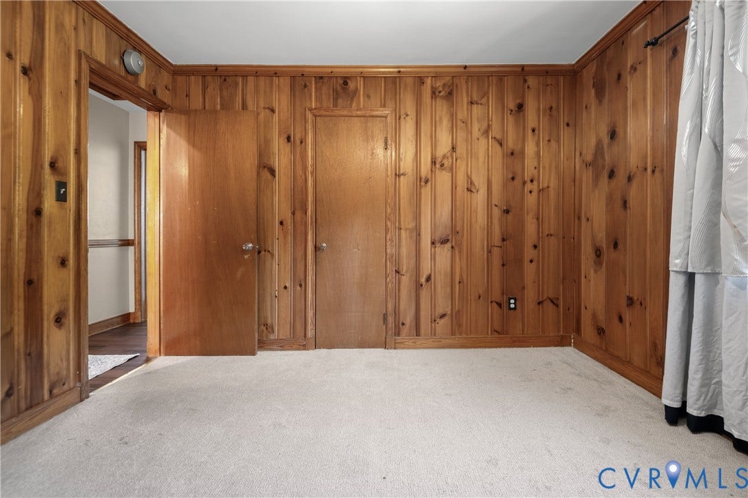 9834 N Wagstaff Circle, Mechanicsville, VA 23236 Room featuring floor-to-ceiling wood paneling, solid wood interior doors, and neutral carpeting