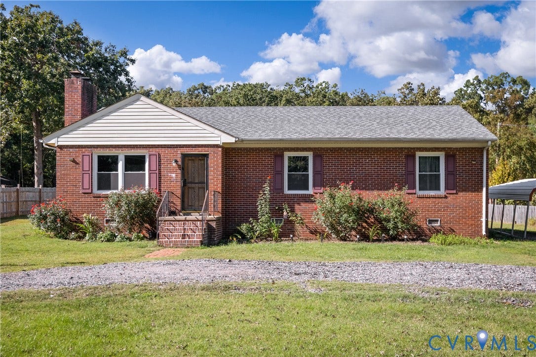 9834 N Wagstaff Circle, Mechanicsville, VA 23236 Red brick exterior featuring a masonry chimney, gabled roofline, decorative window shutters, and a covered brick-step entryway
