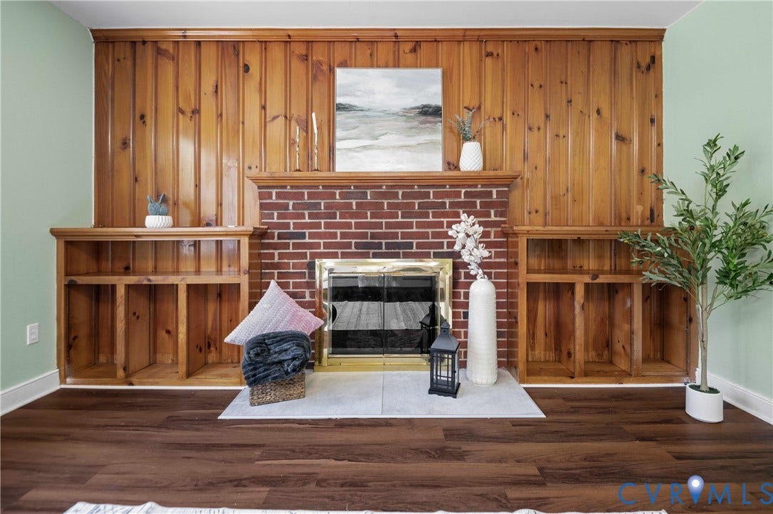 9834 N Wagstaff Circle, Mechanicsville, VA 23236 Floor-to-ceiling wood paneling, red brick fireplace, built-in shelving, stone hearth, and wood-finish flooring