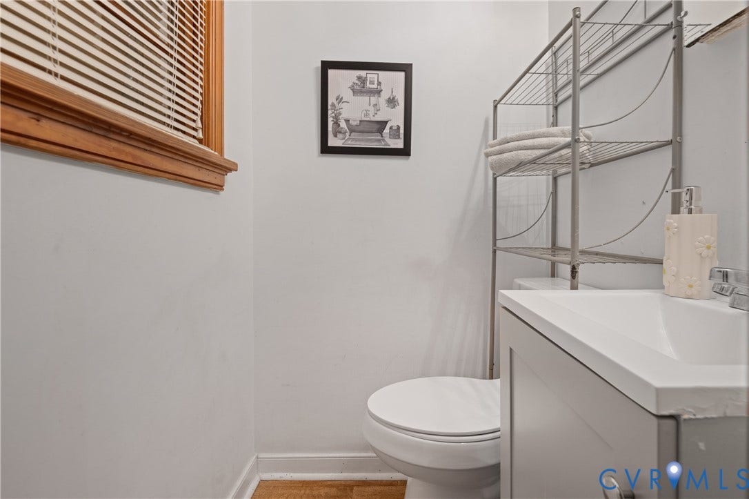 9834 N Wagstaff Circle, Mechanicsville, VA 23236 Bathroom featuring a grey vanity cabinet, integrated sink with a metallic faucet, wood-finish flooring, and a window with wood-tone blinds