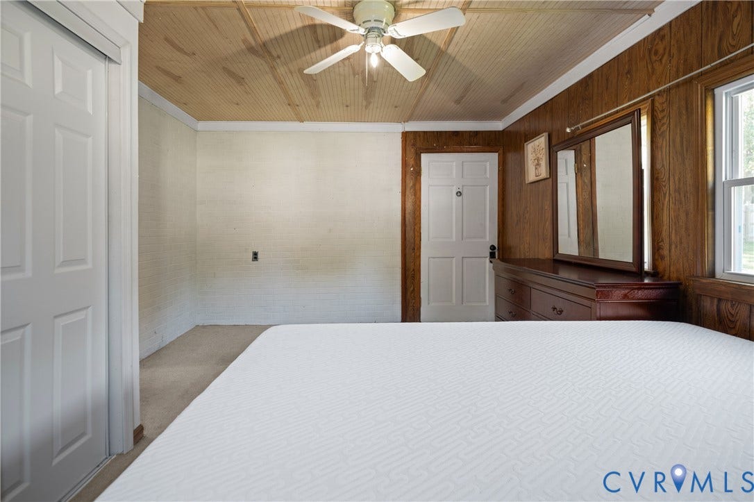 9834 N Wagstaff Circle, Mechanicsville, VA 23236 Beadboard ceiling with center-mounted ceiling fan, wood-paneled wall, white paneled doors, and multi-pane window