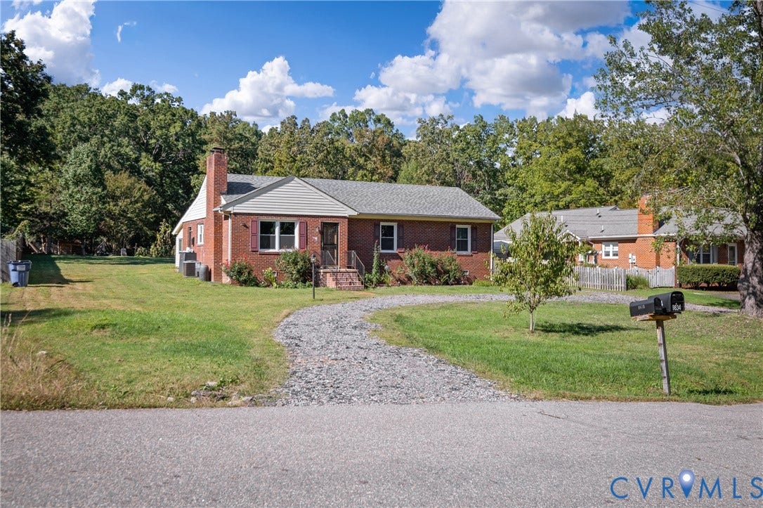 9834 N Wagstaff Circle, Mechanicsville, VA 23236 Single-story brick exterior featuring a gable roof, vinyl-sided gables, shuttered windows, and a gravel driveway