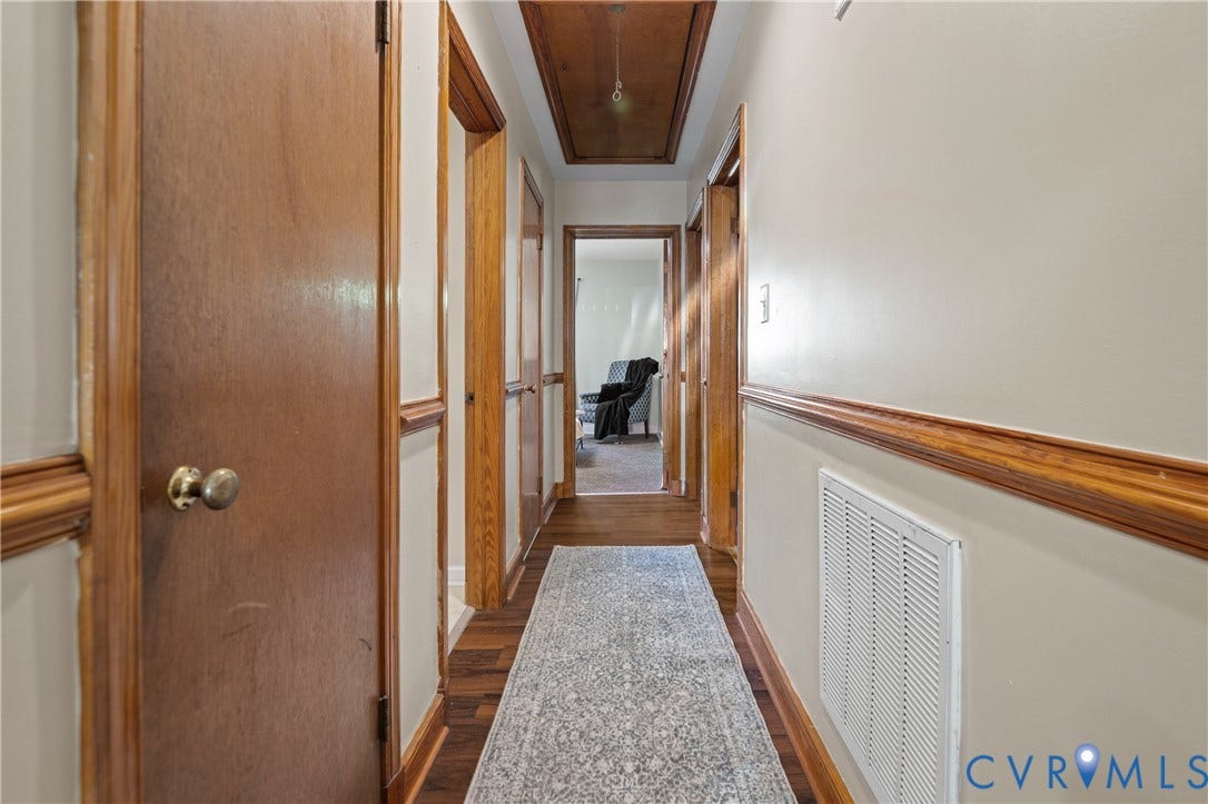 9834 N Wagstaff Circle, Mechanicsville, VA 23236 Interior hallway featuring wood-finish flooring, wood door trim and wainscoting, recessed ceiling paneling, and interior wood doors