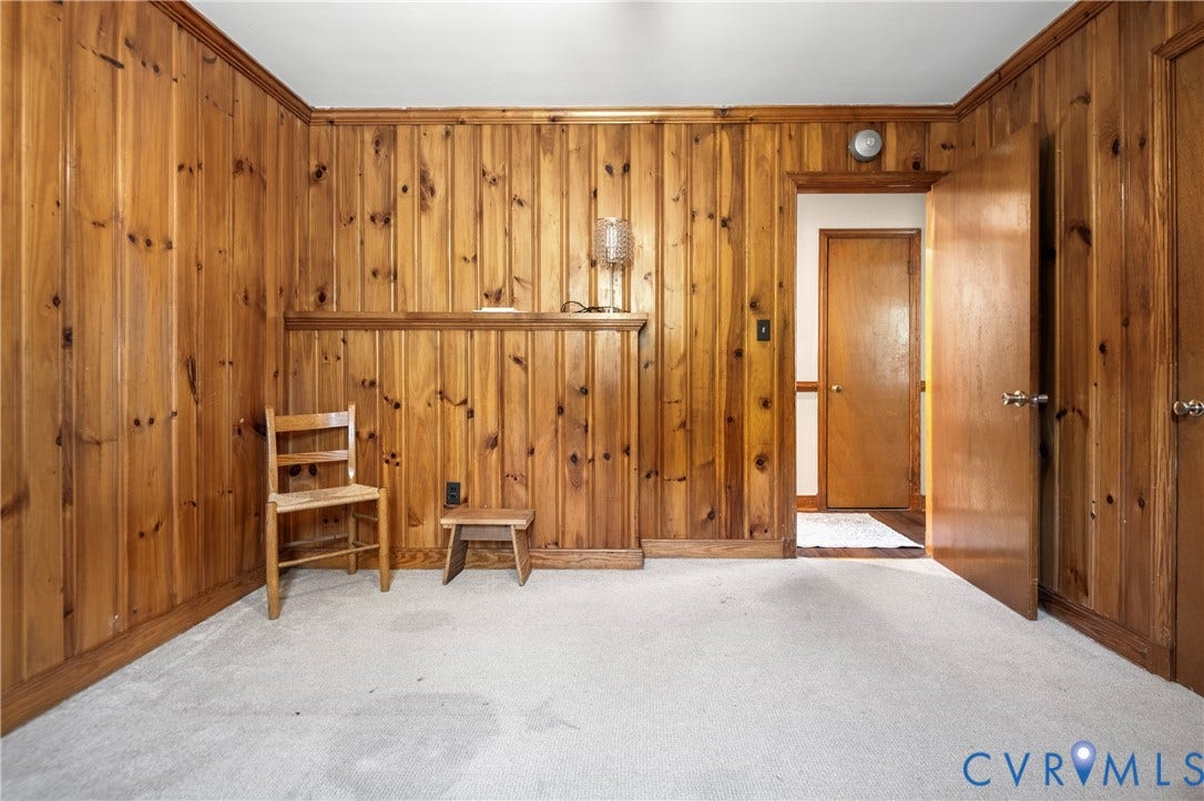 9834 N Wagstaff Circle, Mechanicsville, VA 23236 Interior space featuring floor-to-ceiling wood paneling, a built-in waist-high wood ledge, and an interior wood door