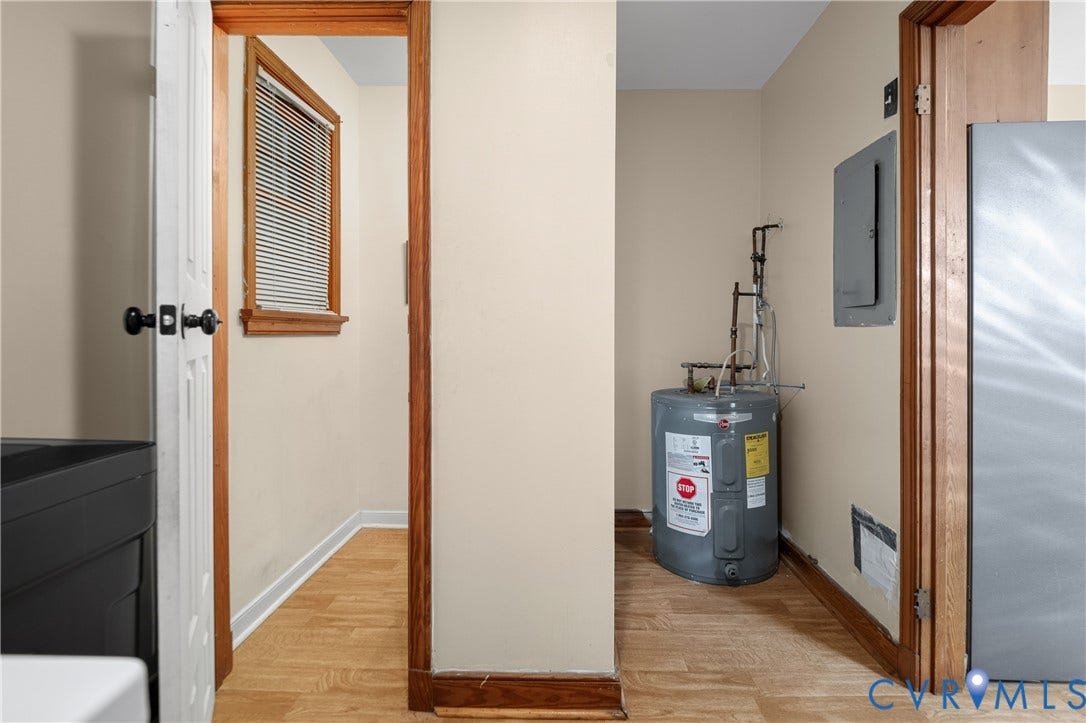 9834 N Wagstaff Circle, Mechanicsville, VA 23236 Utility area featuring wood-finish flooring, natural wood door casings, a recessed window with blinds, and a dedicated water heater