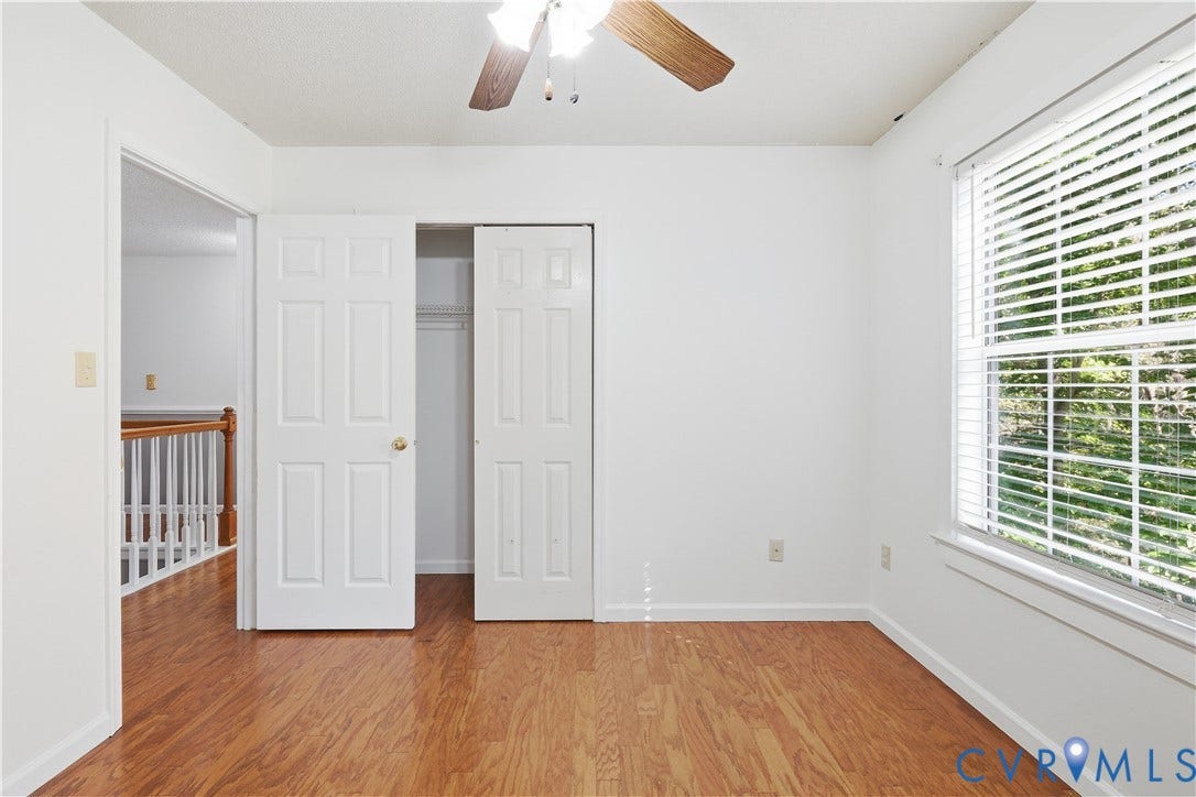 7652 Thacher Drive, Toano, VA 23168 Room featuring wood-finish flooring, a double-door closet, a window with horizontal blinds, and a ceiling fan with integrated lighting