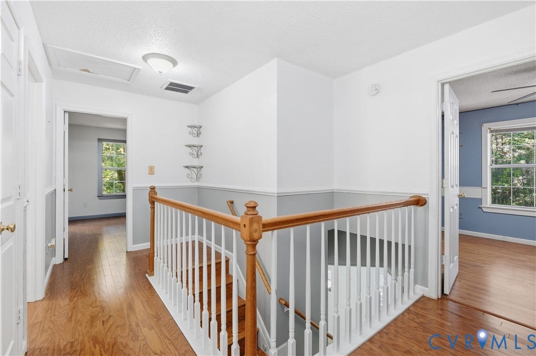 7652 Thacher Drive, Toano, VA 23168 Landing area featuring wood-finish flooring, a traditional wood and white spindle railing, chair rail molding, and built-in wall shelving