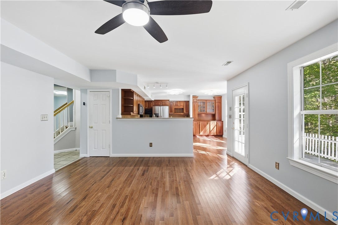 7652 Thacher Drive, Toano, VA 23168 Wood-finish flooring, natural wood cabinetry, glass-paneled entry door, ceiling fan with integrated lighting, and multipane windows