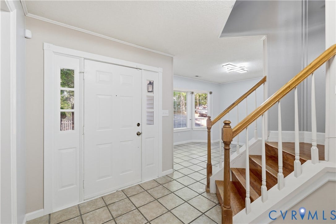 7652 Thacher Drive, Toano, VA 23168 Entryway featuring tile flooring, staircase with wood-finish treads, decorative white balusters, and a paneled front door with glass sidelights