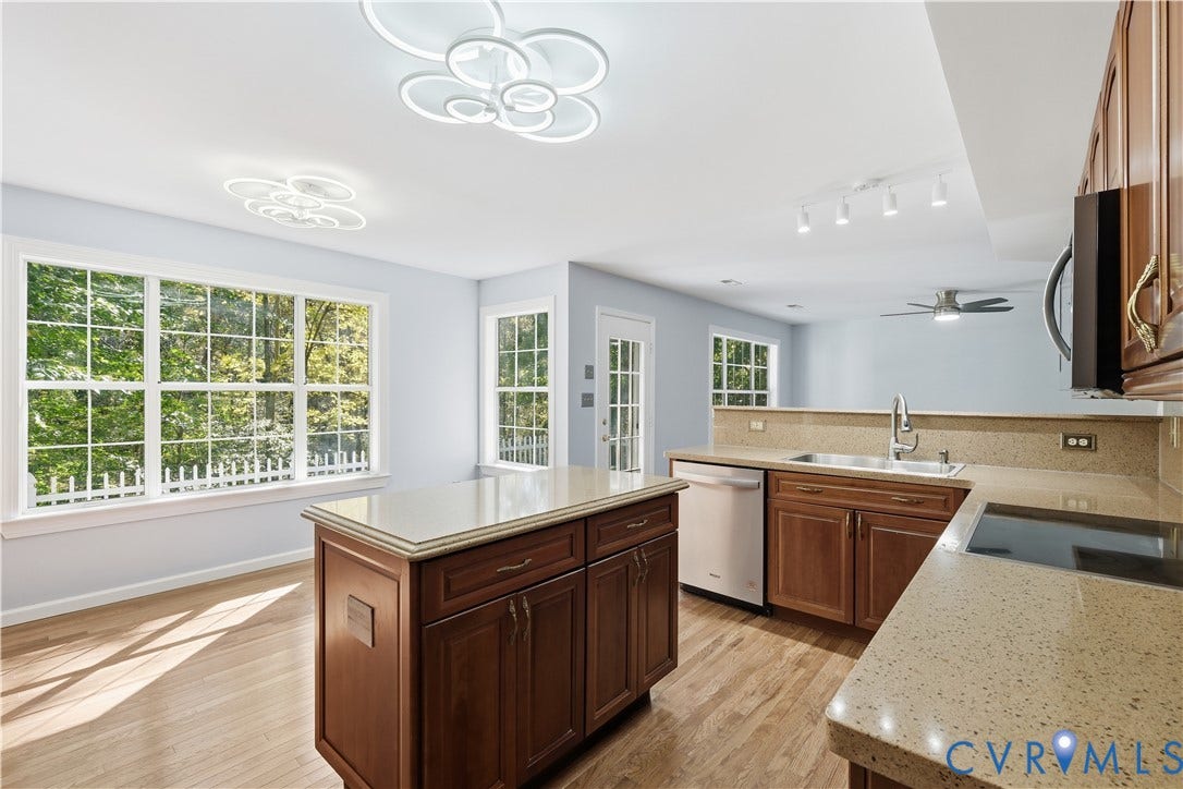 7652 Thacher Drive, Toano, VA 23168 Kitchen featuring wood cabinetry, solid-surface countertops, center island, wood-finish flooring, and modern geometric flush-mount lighting