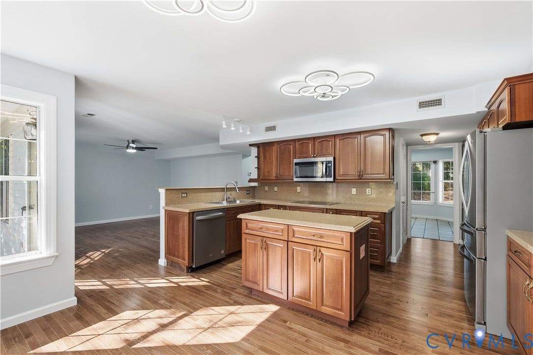 7652 Thacher Drive, Toano, VA 23168 Kitchen featuring wood cabinetry, stone-finish countertops, stainless steel appliances, a central island, and wood-finish flooring