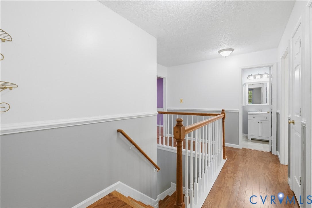 7652 Thacher Drive, Toano, VA 23168 Hallway featuring wood-finish flooring, white railings with a wooden handrail, chair rail molding, and flush-mount ceiling lighting