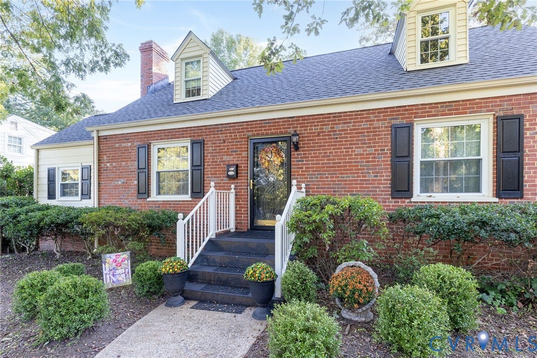 5211 W Grace Street, Richmond, VA 23226 Red brick exterior featuring two gabled dormers, a prominent brick chimney, and decorative window shutters