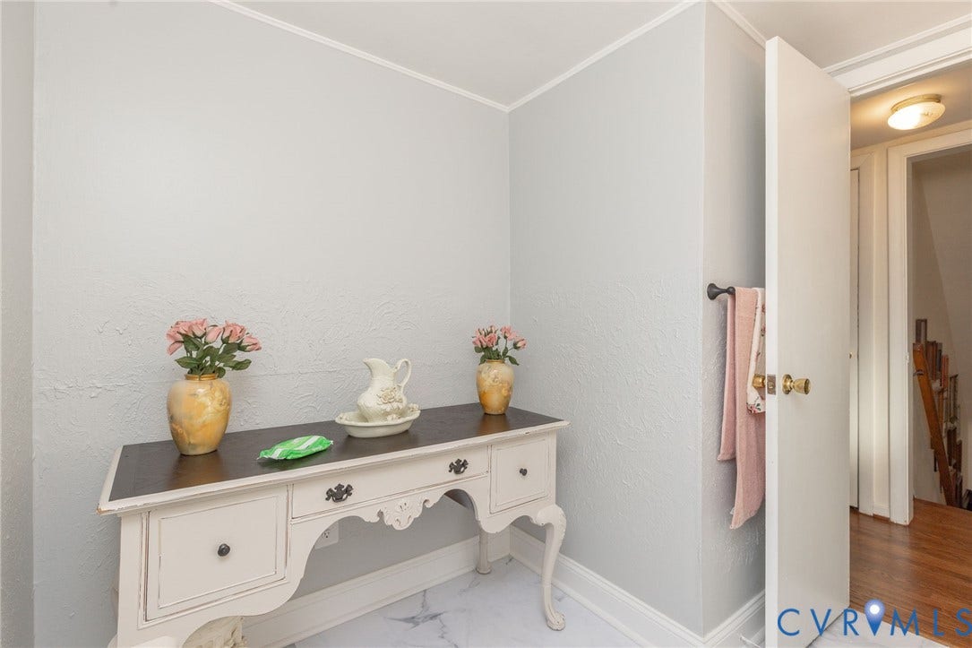 5211 W Grace Street, Richmond, VA 23226 Wall-mounted dark finish towel bar, solid core interior door with brass hardware, and neutral wall texturing