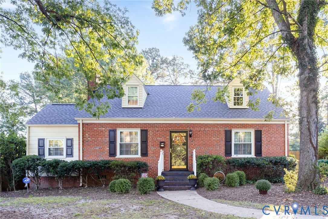 5211 W Grace Street, Richmond, VA 23226 Traditional brick exterior featuring two roof dormers, contrasting shutters, and a concrete front walkway