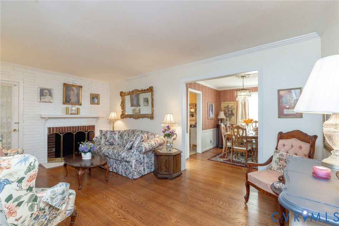 5211 W Grace Street, Richmond, VA 23226 Living area featuring a white-painted brick fireplace with a wood mantel, crown molding, and wood-finish flooring