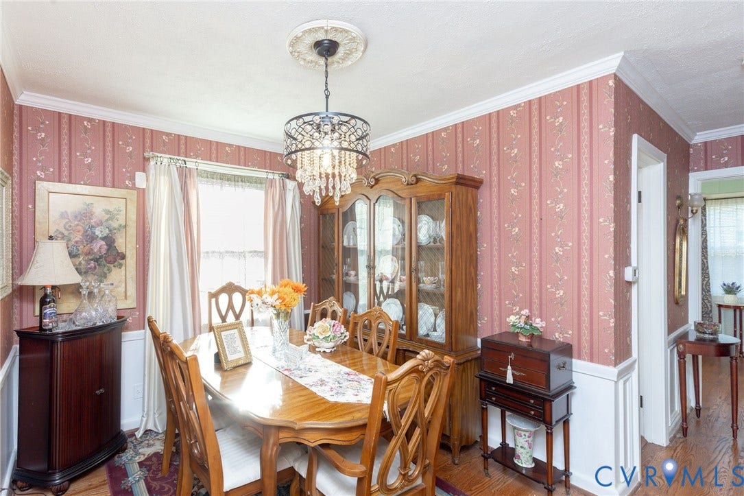 5211 W Grace Street, Richmond, VA 23226 Dining area featuring crown molding, wainscoting, wood-finish flooring, and a decorative ceiling medallion with an ornate crystal-style chandelier