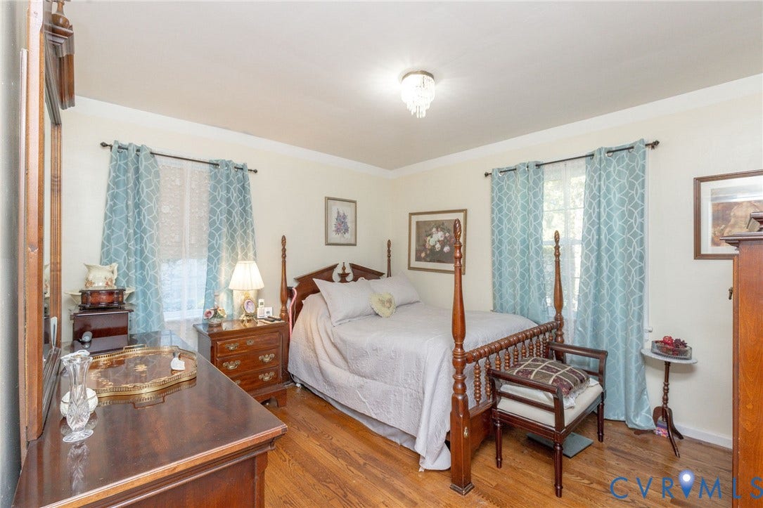 5211 W Grace Street, Richmond, VA 23226 Room featuring wood-finish flooring, crown molding, and a central crystal-style flush mount ceiling light