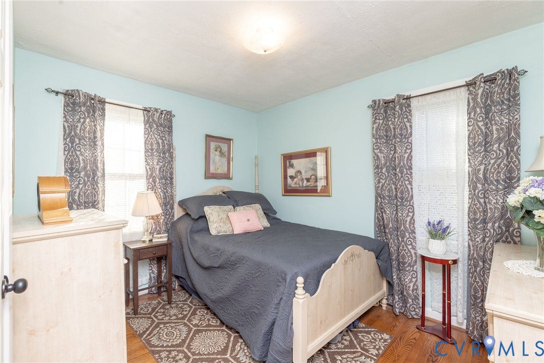 5211 W Grace Street, Richmond, VA 23226 Interior space featuring wood-finish flooring, two windows with double curtain rod hardware, and a center-mounted ceiling light fixture