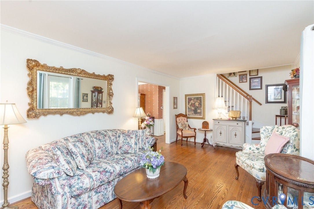 5211 W Grace Street, Richmond, VA 23226 Living area featuring hardwood flooring, crown molding, and a wooden staircase with a white balustrade