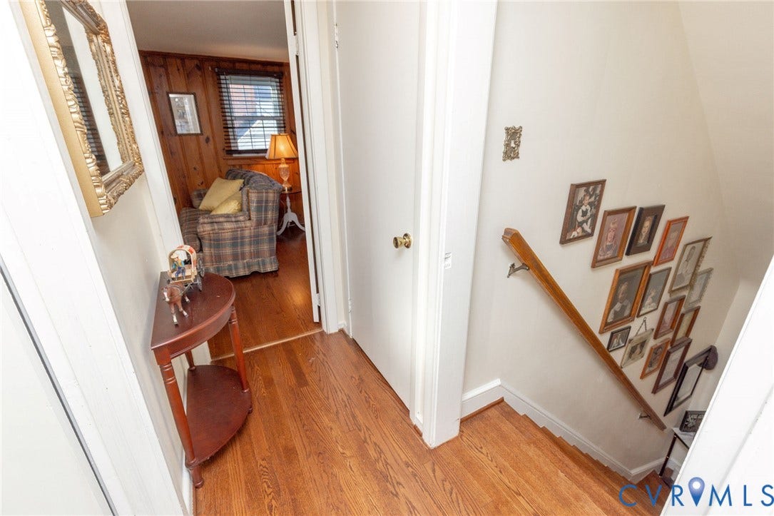 5211 W Grace Street, Richmond, VA 23226 Hardwood flooring, natural wood-paneled walls, and a wooden handrail with a metal support bracket