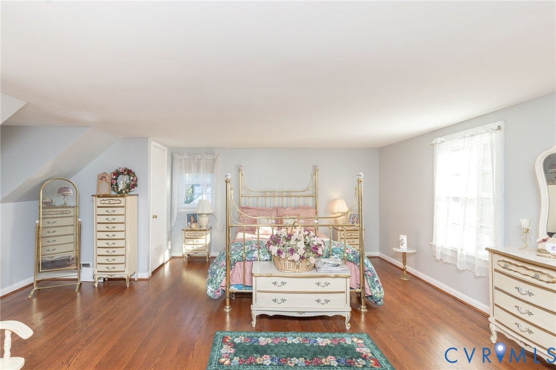 5211 W Grace Street, Richmond, VA 23226 Spacious room featuring wood-finish flooring, neutral wall paint, and multiple windows with white trim