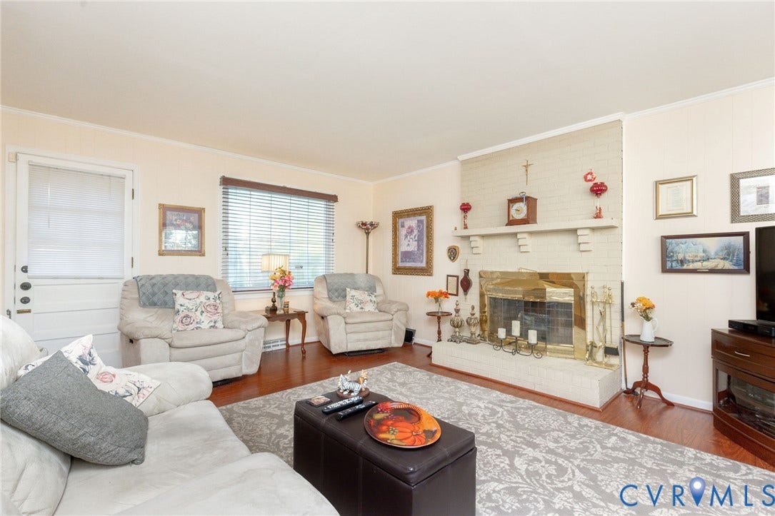 5211 W Grace Street, Richmond, VA 23226 Living room featuring wood-finish flooring, a painted brick fireplace with a decorative mantel, and a multi-pane door