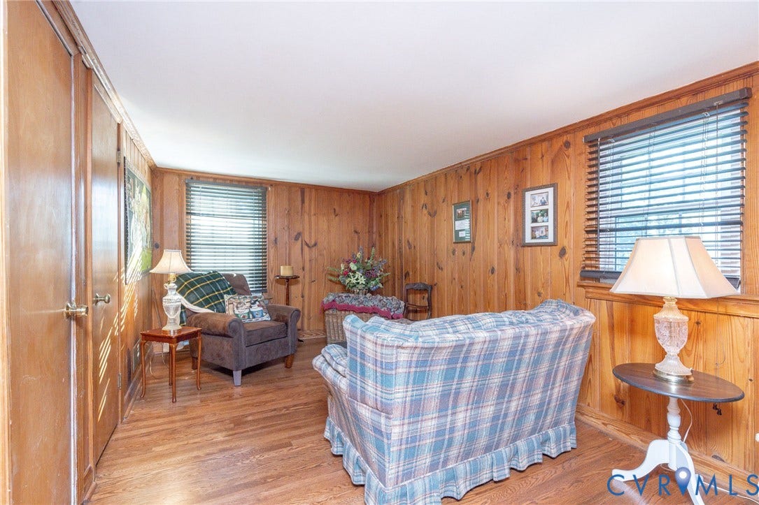 5211 W Grace Street, Richmond, VA 23226 Interior room featuring wood-paneled walls, wood-finish flooring, and multiple windows with horizontal blinds