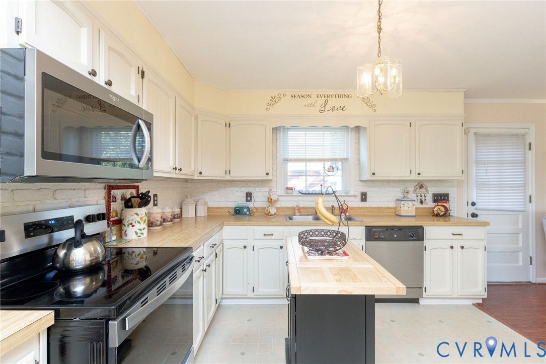 5211 W Grace Street, Richmond, VA 23226 Kitchen featuring white cabinetry, wood-finish countertops, stainless steel microwave, integrated dishwasher, and central island