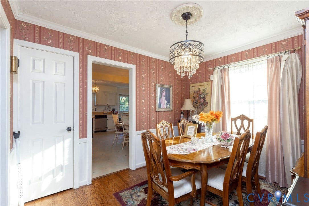 5211 W Grace Street, Richmond, VA 23226 Dining area featuring hardwood flooring, wainscoting, crown molding, and a tiered crystal chandelier with a decorative ceiling medallion