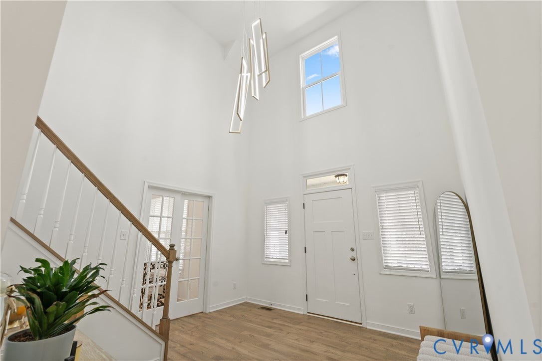 13807 Denleigh Court, Midlothian, VA 23112 Entryway featuring high ceilings, wood-finish flooring, a contemporary geometric pendant light fixture, a staircase with a wooden handrail, and white-paned interior doors