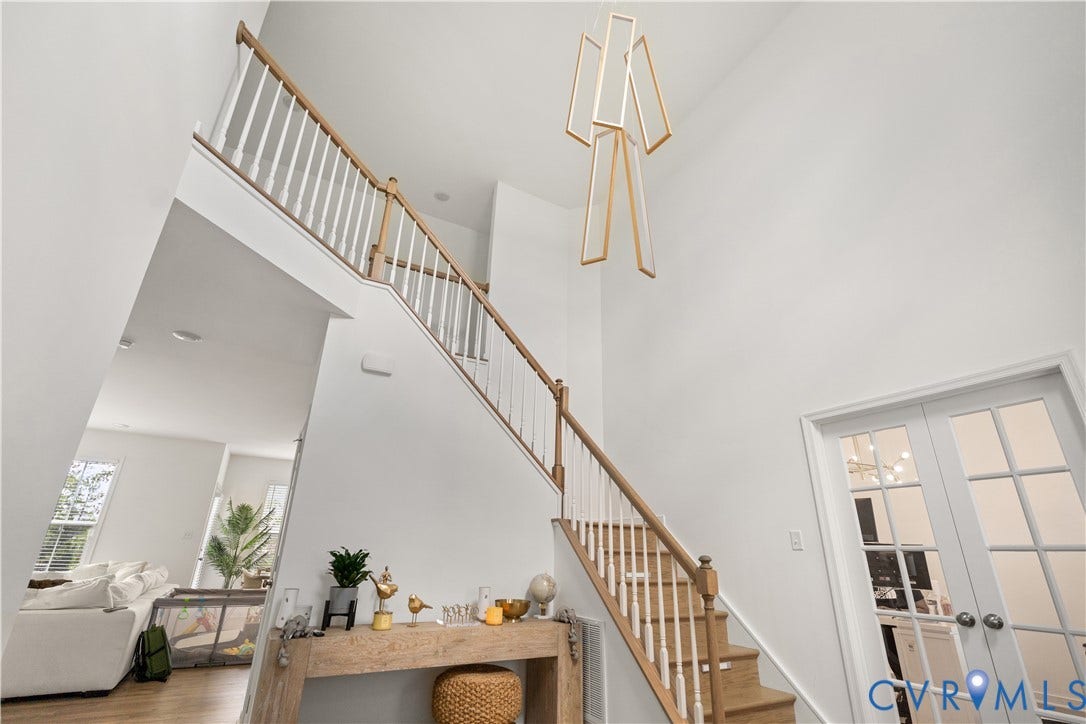13807 Denleigh Court, Midlothian, VA 23112 Double-height ceiling featuring a contemporary geometric chandelier, staircase with wood-finish treads and white balusters, and French doors with glass panes