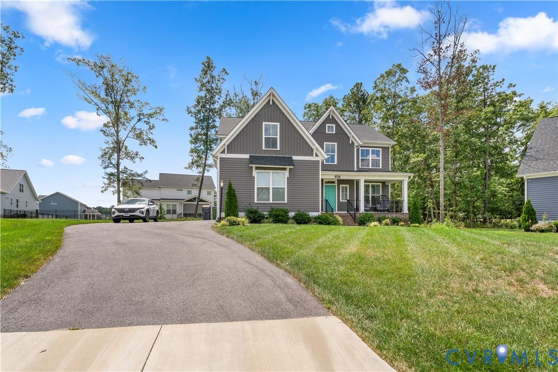 13807 Denleigh Court, Midlothian, VA 23112 Two-story exterior featuring dark vertical siding, a covered front porch with brick foundation detail, gabled rooflines, and an asphalt driveway