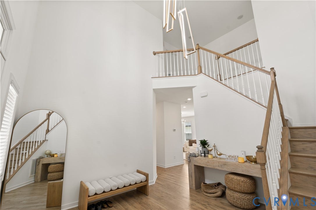 13807 Denleigh Court, Midlothian, VA 23112 Two-story foyer featuring high ceilings, wood-finish flooring, a contemporary geometric chandelier, and a staircase with white balusters and a wood-finish handrail