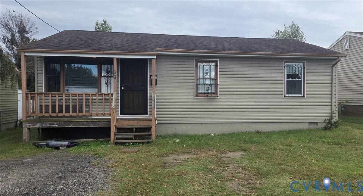 1342 Steel Street, Petersburg, VA 23803 Single-story residence featuring light-toned horizontal siding, a covered front porch with wood railing, and a gabled roof