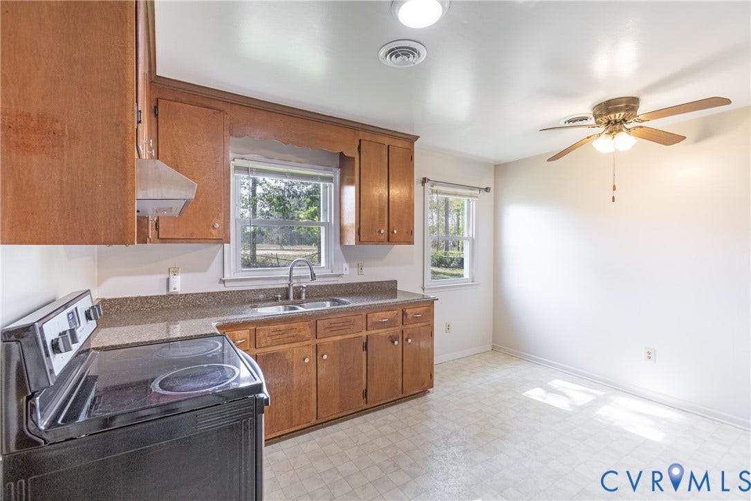 542 Petty Street, Petersburg, VA 23805 Kitchen featuring wood cabinetry, stone-surface countertops, dual-basin stainless steel sink, black electric range, and ceiling fan with integrated lighting