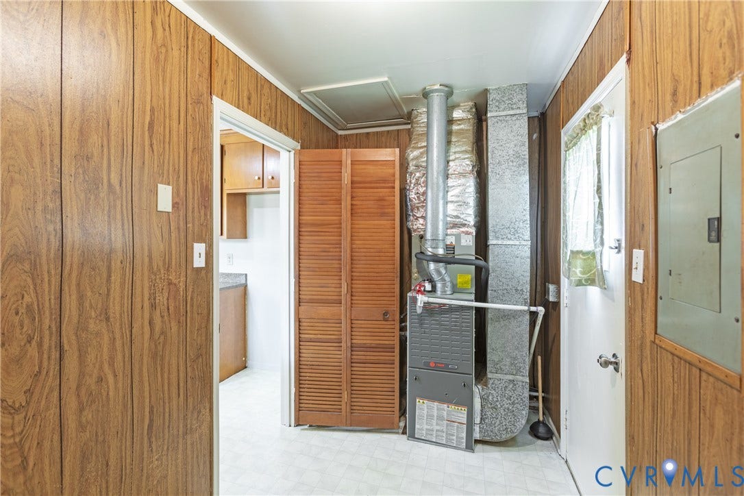 542 Petty Street, Petersburg, VA 23805 Utility room featuring wood-finish paneling, louvered wood closet doors, and a forced-air furnace unit