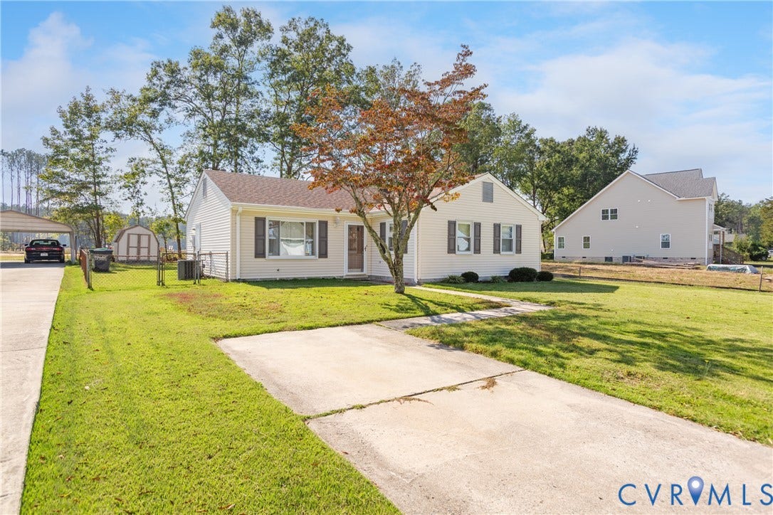 542 Petty Street, Petersburg, VA 23805 Single-story residence featuring light-colored siding, dark shutters, an asphalt shingle roof, a concrete driveway, and a detached storage structure