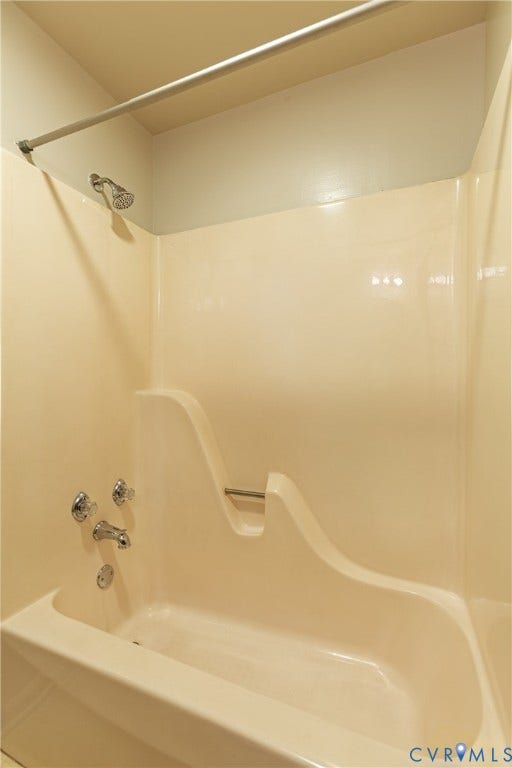 542 Petty Street, Petersburg, VA 23805 Full-surround acrylic bathtub enclosure with integrated molded soap dish, chrome showerhead, polished metal faucet assembly, and overhead tension curtain rod