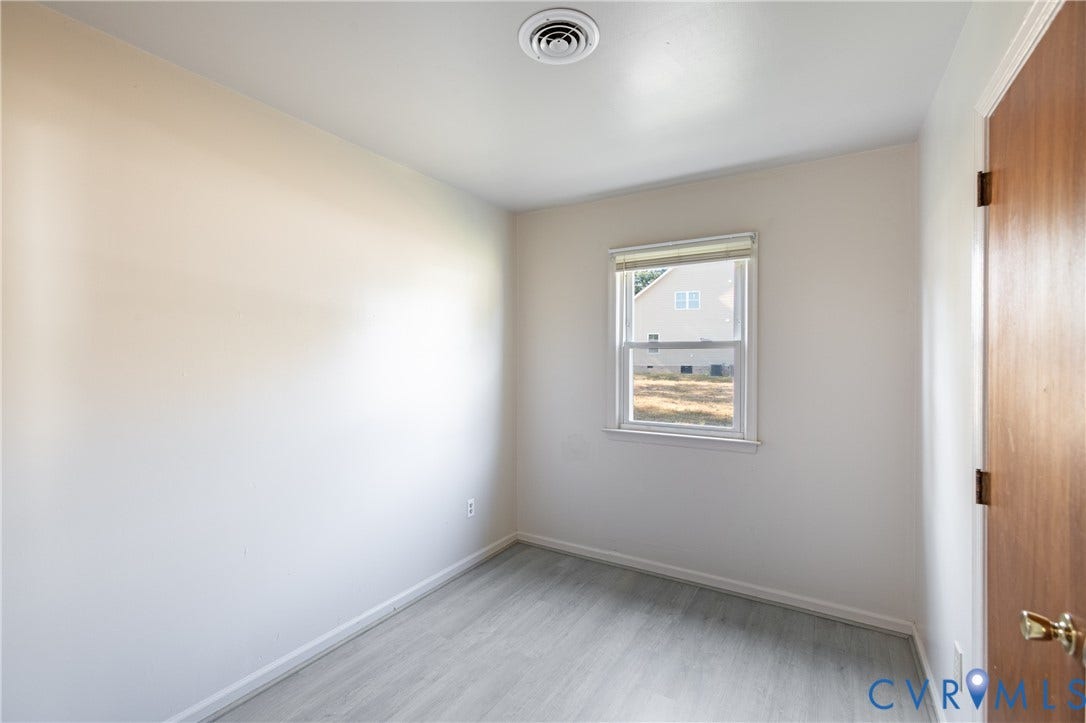 542 Petty Street, Petersburg, VA 23805 Interior room featuring neutral-toned walls, wood-finish flooring, and a single window with white trim