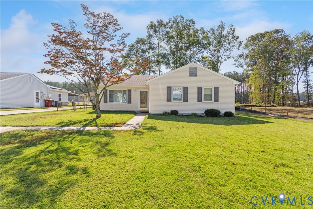 542 Petty Street, Petersburg, VA 23805 Single-story residence featuring light-colored siding, dark shutters, a front bay window, and an expansive lawn