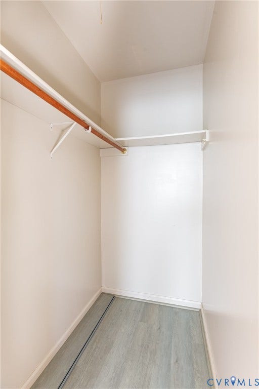 542 Petty Street, Petersburg, VA 23805 Walk-in closet featuring wood-finish flooring, white shelving, and a mounted hanging rod