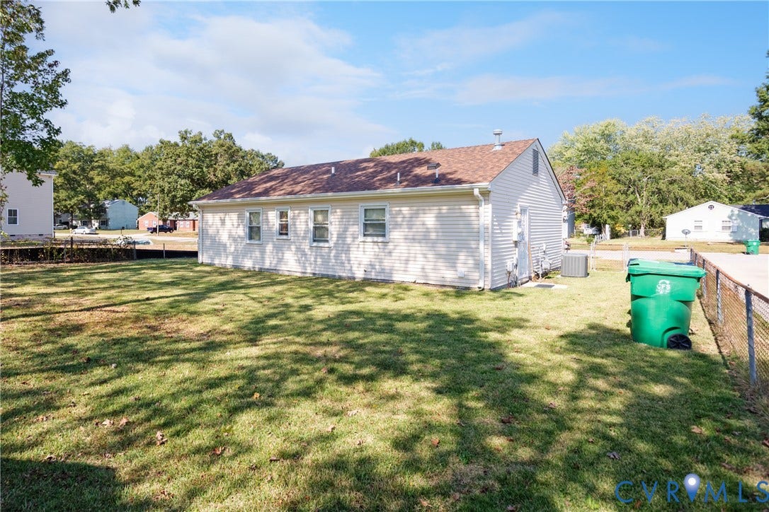 542 Petty Street, Petersburg, VA 23805 Exterior profile featuring light-toned vinyl siding, an asphalt shingle roof, and a fenced-in grassy yard