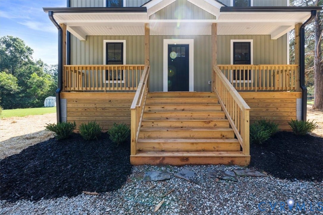 2242 Lakeview Drive, Powhatan, VA 23139 Exterior featuring vertical board-and-batten siding, a covered front porch with wood railings, and a solid-color front door