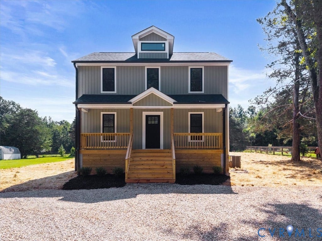 2242 Lakeview Drive, Powhatan, VA 23139 Two-story residence featuring vertical siding, a front porch with natural wood railings, a central dormer window, and a dark shingled roof