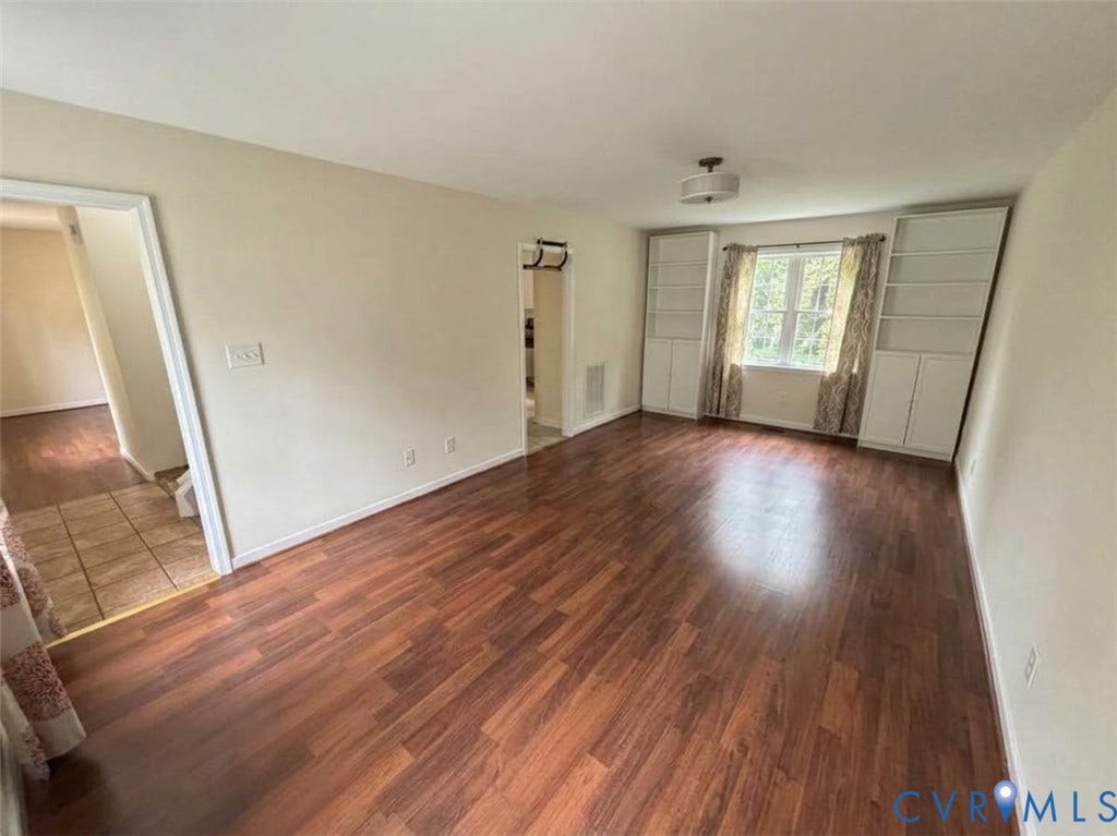 Interior space featuring wood-finish flooring, dual built-in floor-to-ceiling cabinetry units, and a single-hung window