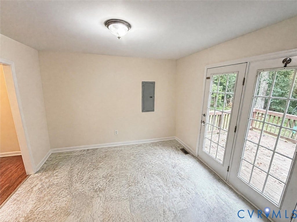 Room featuring tile flooring, glass-paneled double doors, and a flush-mount ceiling light