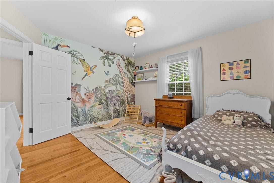 6956 Old Westham Road, Stratford Hills/Cherokee Road, Richmond, VA 23225 Bedroom featuring wood-finish flooring, a wall-mounted floating display shelf, a single-hung window with shutters, and a multi-panel interior door