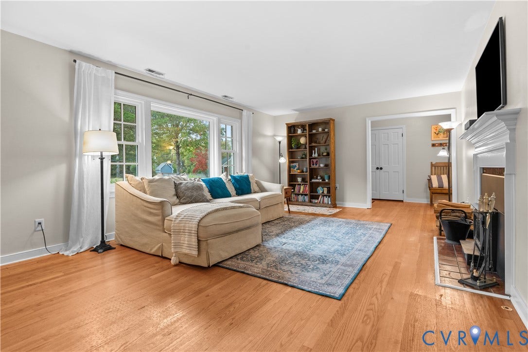 6956 Old Westham Road, Stratford Hills/Cherokee Road, Richmond, VA 23225 Living area featuring wood-finish flooring, a large picture window, and a fireplace with a traditional mantel and ceramic tile hearth